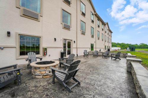 a group of benches sitting outside of a building at Cobblestone Hotel & Suites - Russells Point at Indian Lake in Russells Point