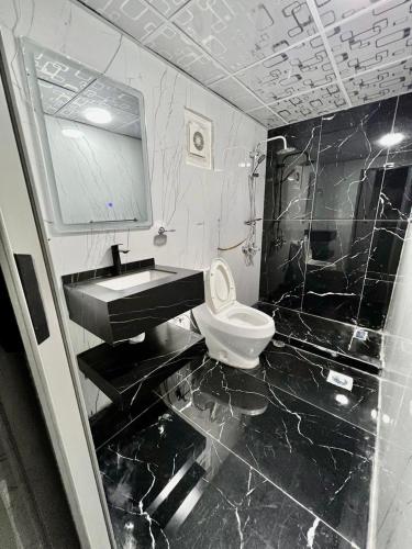 a black and white bathroom with a sink and a toilet at Wadi Rum Marina Camp in Wadi Rum