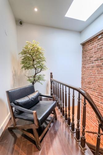 a chair on a staircase with a tree on the wall at Self Check-In Boutique Hotel - Quartier latin - Room 103 in Montréal