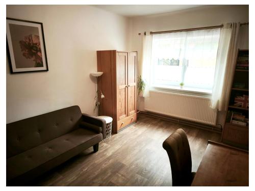 a living room with a couch and a window at Apartmán Doubrava in Puclice