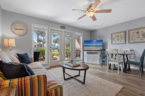 ein Wohnzimmer mit Sofa und Tisch in der Unterkunft Grand Caribbean East Poolside Palms in Pensacola