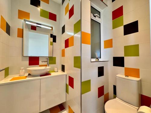 a colorful bathroom with a toilet and a sink at St Julians Hillside villa with Pool in Is-Swieqi