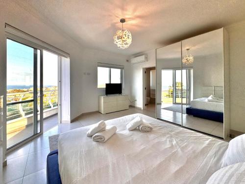 a bedroom with a large white bed and a television at St Julians Hillside villa with Pool in Is-Swieqi