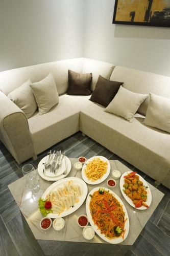 a table with plates of food on a couch at The Khushi Hotel And Resorts in Murree