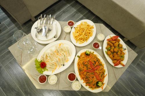 a table with four plates of food on it at The Khushi Hotel And Resorts in Murree
