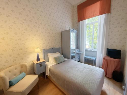 クリアにあるHotel Do Parque, Boutique Hotel - Curiaのベッドと椅子のある小さな寝室