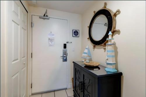 a mirror on top of a dresser next to a door at Bang For Your Buck Hotel Condo On Daytona Beach with Kitchen and Ocean View in Daytona Beach