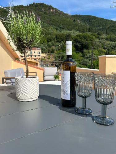 a bottle of wine sitting on a table with two wine glasses at Sami Loft in Sami