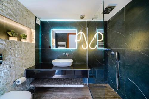 a bathroom with a sink and a glass shower at Golden Sunrise Apartments in Chrysi Ammoudia