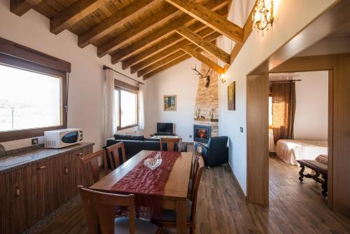 1 dormitorio y sala de estar con mesa de comedor. en Casas Rurales Cuatro Valles, en Naredo de Fenar