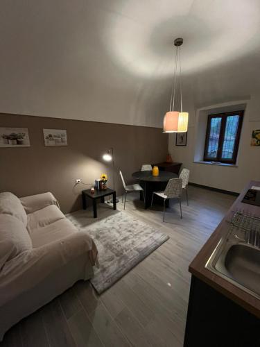 een slaapkamer met een bed, een wastafel en een tafel bij La petite maison Soleil in Biella