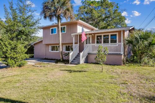 una casa rosa con una bandera delante de ella en Near Downtown Beach House&Apt - Woodland Escape, en Pensacola