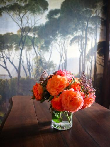 a glass vase filled with flowers on a table at Au cœur des prés in Montmort