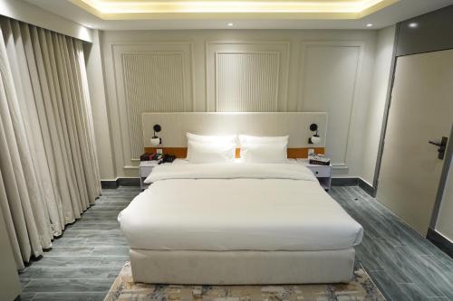 a large white bed in a hotel room at The Khushi Hotel And Resorts in Murree