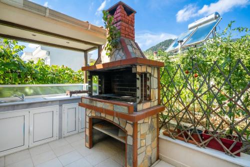 a outdoor kitchen with a brick fireplace on a patio at Golden Sunrise Apartments in Chrysi Ammoudia