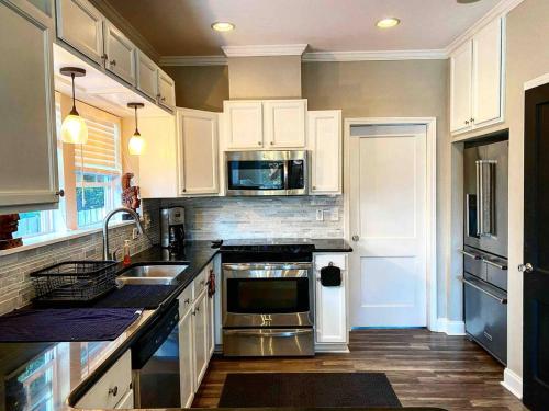 a kitchen with stainless steel appliances and white cabinets at Atlanta Lounge in Midtown in Atlanta