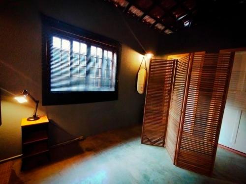 a room with a window and a table with a lamp at Loft Industrial in Santo André