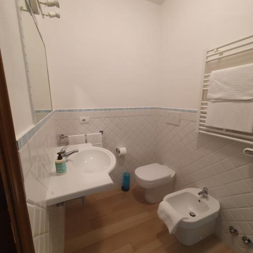 a white bathroom with a sink and a toilet at Agriturismo Costa di Campo in Vernazza