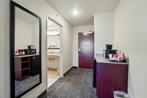 a room with a kitchen with a counter and a mirror at Cobblestone Hotel & Suites - Russells Point at Indian Lake in Russells Point