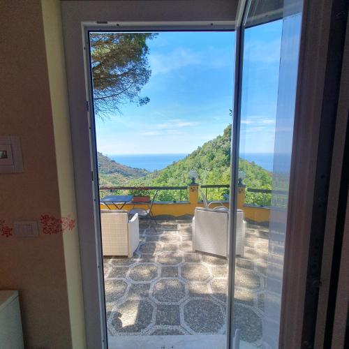 a door to a balcony with a view of the ocean at Agriturismo Costa di Campo in Vernazza