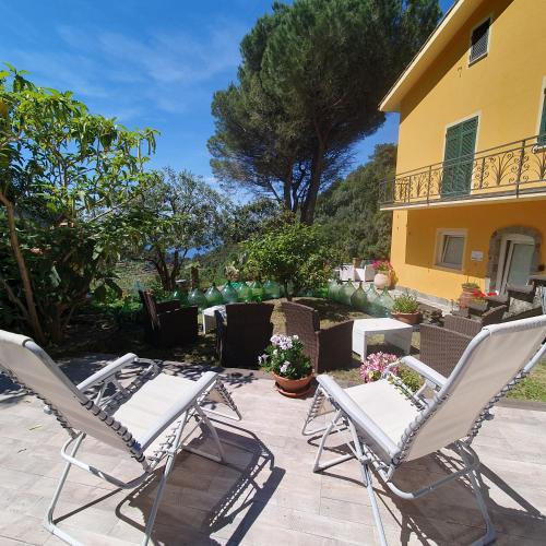 a group of lawn chairs sitting next to a house at Agriturismo Costa di Campo in Vernazza