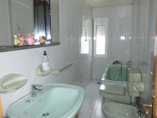a white bathroom with a sink and a toilet at Apartamento Casa Jeronimo in Taramundi