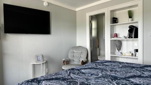 a bedroom with a bed and a television on the wall at Mount Blue Motel in Farmington
