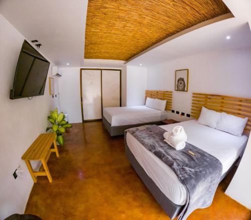 a bedroom with two beds and a flat screen tv at Ávita Lodge in Quesada