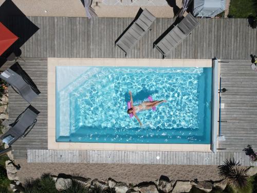 a person swimming in a pool with a painting on it at Au cœur des prés in Montmort