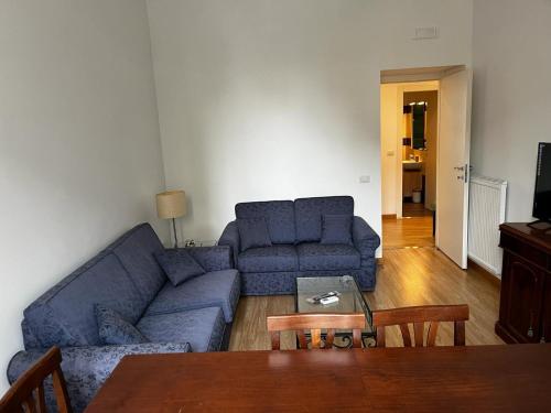 a living room with a blue couch and a table at Be Your Home - MR House in Rome