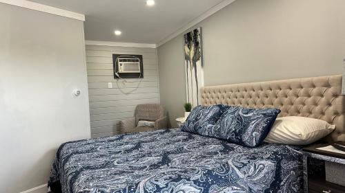 a bedroom with a bed with a blue and white comforter at Mount Blue Motel in Farmington