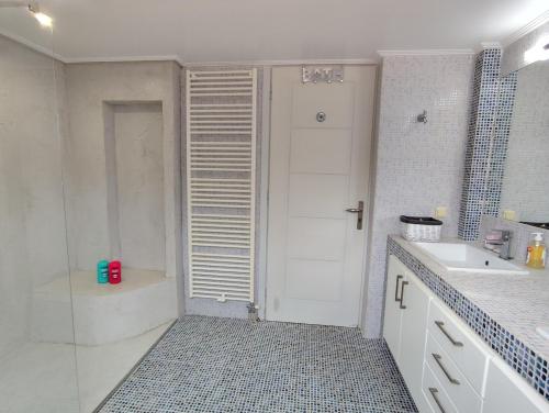 a bathroom with a shower and a tub and a sink at Thimari Sports & Spa with private pool and jacuzzi in Sounio