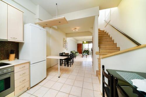 a kitchen with a staircase and a dining room at Golden Sunrise Apartments in Chrysi Ammoudia