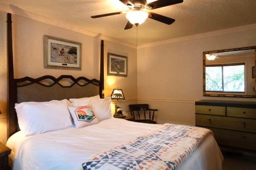 a bedroom with a bed with a ceiling fan at Yellowstone Gateway Inn in Gardiner