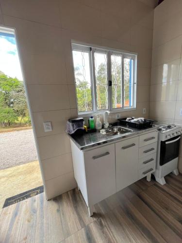 a kitchen with a sink and a stove at Chalés do vale Extrema verde in Extrema