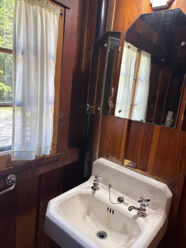 a bathroom with a white sink and a mirror at Addison's Bungalows in Brisco