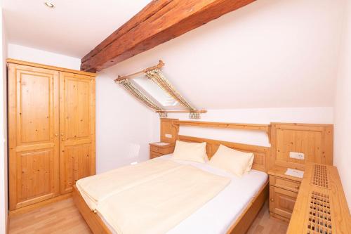 a small bedroom with a bed and wooden cabinets at Altroiterhof in St. Wolfgang