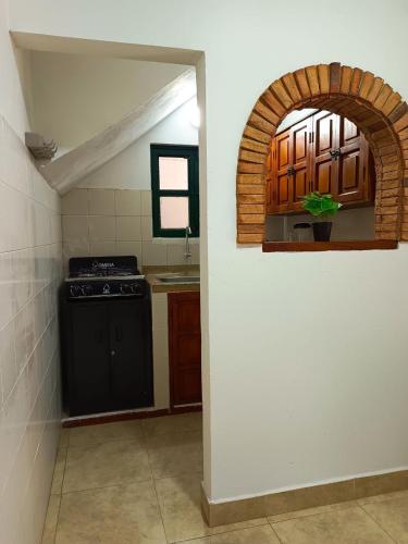 a kitchen with a black stove and an archway at Apartahotel Balcones de Nariño 3 in Villa de Leyva