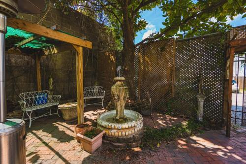 a patio with a fountain and a tree at Victorian Modern Room in Carriage House - Unit B in Savannah