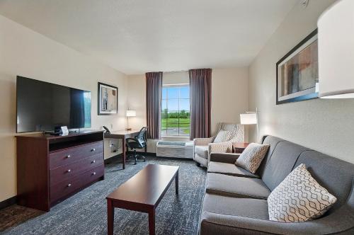 a living room with a couch and a flat screen tv at Cobblestone Hotel & Suites - Russells Point at Indian Lake in Russells Point