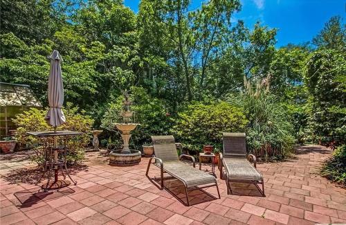 a patio with a table and chairs and an umbrella at Victorian Modern Room in Carriage House - Unit B in Savannah