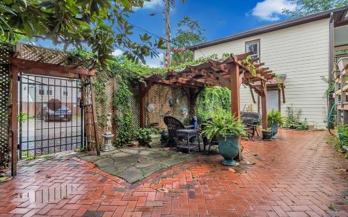 a brick patio with a wooden pergola at Victorian Modern Room in Carriage House - Unit B in Savannah