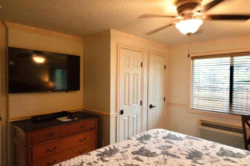 a bedroom with a bed and a dresser and a tv at Yellowstone Gateway Inn in Gardiner