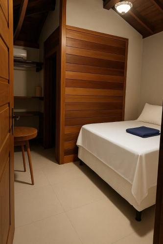 a bedroom with a bed and a wooden headboard at La Playa Bangalô in Arraial d'Ajuda