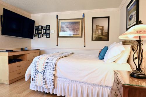 a bedroom with a bed and a desk with a lamp at Yellowstone Gateway Inn in Gardiner