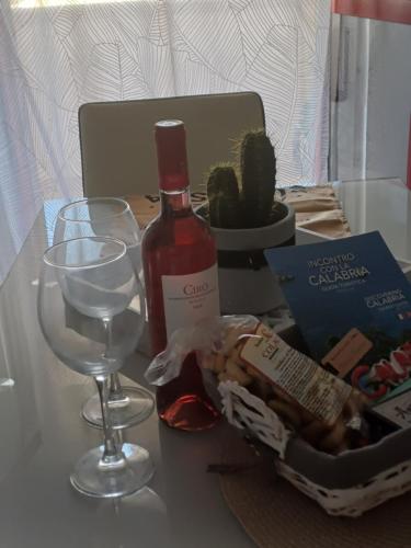 a bottle of wine and two glasses on a table at Appartamento Sun and Sea in Campora San Giovanni