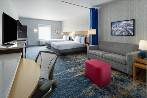 a hotel room with a bed and a couch at Home2 Suites by Hilton Greenville Downtown in Greenville
