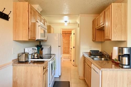 a kitchen with wooden cabinets and a white refrigerator at Yellowstone Gateway Inn in Gardiner