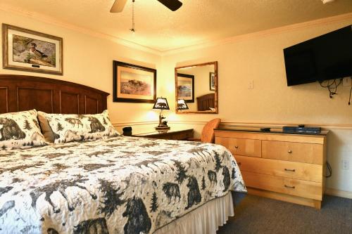 a bedroom with a bed and a flat screen tv at Yellowstone Gateway Inn in Gardiner