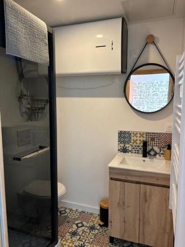une salle de bain avec un lavabo et un miroir dans l'établissement Gîte 4 personnes, à Sainte-Mère-Église